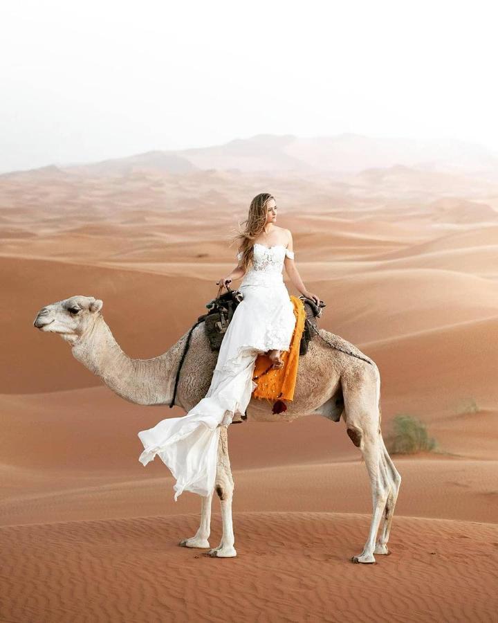 Sahara Majestic Luxury Camp Hotel Merzouga Exterior foto A woman riding a camel in the desert